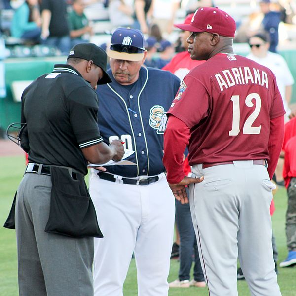 Home plate umpire Malachi Moore reviews the lineup cards from both teams before a 2016 minor league baseball game