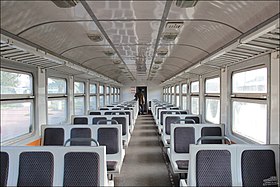 Салон промежуточного вагона дизель-поезда ДР1А с общими пластиковыми сиденьями с разделёнными мягкими подкладками