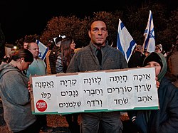 Demonstrators against the judicial reform in Haifa, 11 January 2023. The protester's sign reads a quote from the Hebrew Bible: "How is the faithful city become an harlot! Thy princes are rebellious, and companions of thieves: every one loveth gifts, and followeth after rewards." (Isaiah 1:21-23) hpgnh bKHyph ngd mmSHlt ySHrAl hSHlvSHym vSHb` vhrpvrmh hmSHptyt vhklklyt, kykr KHvrb 11 bpbrvAr 2023 134.jpg