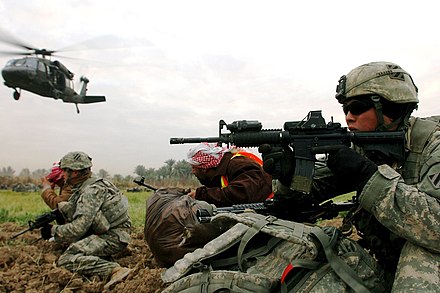 US soldiers and Sunni Arab tribesmen scan for enemy activity in a farm field in southern Arab Jibor, January 2008