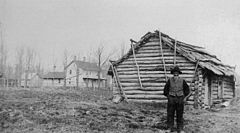 Andrew Peterson framför sin första "Shanty" i Minnesota. Kortet är taget 1885 och "Shantiet" byggdes 1855.