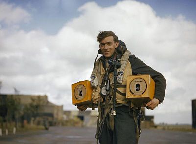 Membre d'équipage d'un avion allié portant des caisses à pigeons en octobre 1942.