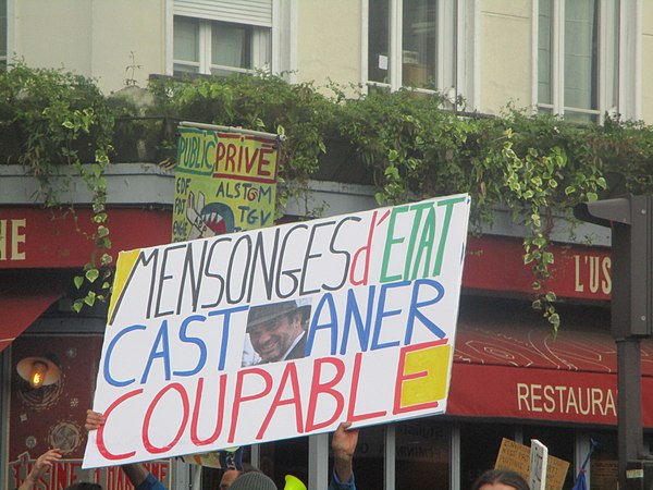 Yellow vest demonstrator holding a sign against Castaner during a protest in May 2019