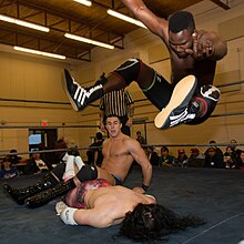 Chief Ade (right) executes a leg drop. Chief Ade leg drop.jpg