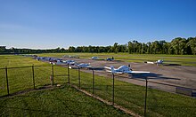 Planes parked at the College Park airport with the runway on the background. College Park airport building runway.jpg