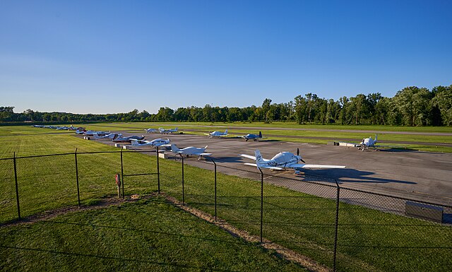 Planes parked at the College Park airport with the runway on the background.