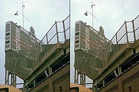 The "Cubs Win" flag with the old white-on-blue scheme, rippling in the breeze after a victory in a 1977 game Cubs Win flag 1977.JPG