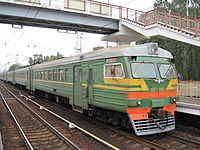 Tren eléctrico ED2T-0007 sobre 1 andén y puente peatonal