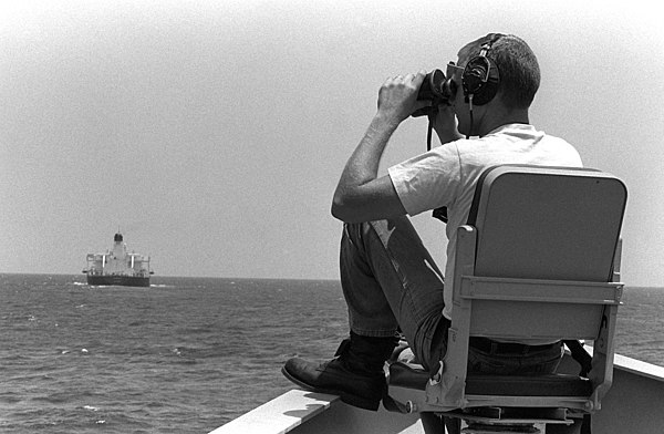 A US Navy sailor scans for mines from the bow of the guided missile frigate USS Nicholas during an Operation Earnest Will convoy mission, June 1988