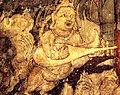 India, in Ajanta Caves, Cave 1, c. 450-490 AD. Kinnara with "kacchapī veena" (Sanskrit for "tortise veena") or panchangi veena (5-stringed veena). Part of the painting Bodhisattva Padmapani.[121][122][note 2]