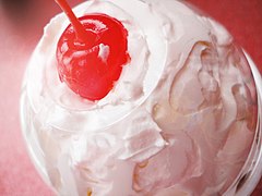 Milkshake topped with whipped cream and a maraschino cherry