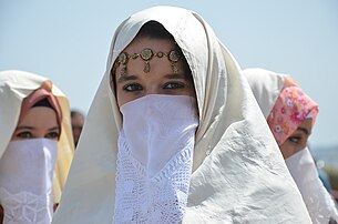 Une femme vetue en haïk (vêtement féminin porté au Maghreb), lors d'une sortie au port d'Alger. (définition réelle 3 696 × 2 448)