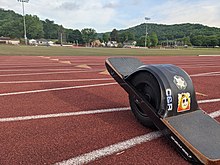 A Onewheel XR with optional fender and decorative stickers on a college running track Onewheel XR track.jpg