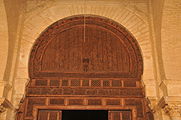Timpan en arquitectura: partida superiora d'una pòrta ricament escultada de la Granda Mesquita de Kairuan (en Tunisia); lo timpan es escultat d'un vase estilizat qu'a partir d'el surgisson d'enlaçaments vegetals