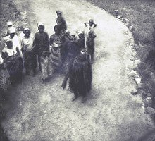 Mende women with a masked Sande society leader. SierraLeone015.jpg