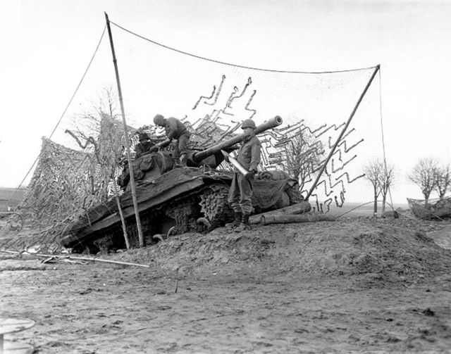 Company C, 702d Tank Destroyer Battalion, 2nd Armored Division, tank destroyer on dug-in ramp has plenty of elevation to hurl shells at long range ene