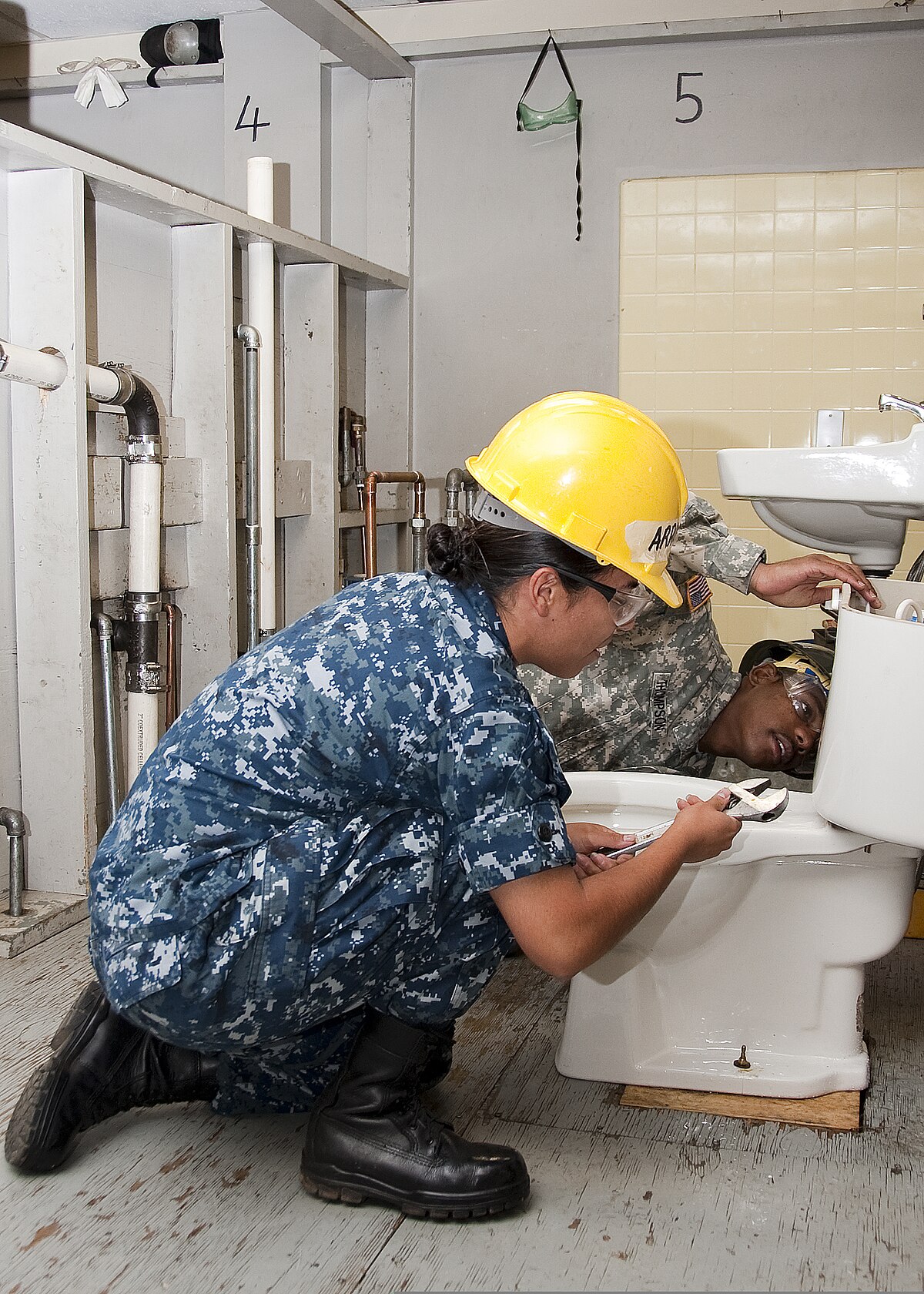 https://upload.wikimedia.org/wikipedia/commons/thumb/4/43/U.S._Navy_Construction_Apprentice_Perla_Arroyojaime%2C_foreground%2C_and_U.S._Army_Pfc._Jimmy_Thompson%2C_with_the_366th_Training_Squadron%2C_attach_a_toilet_tank_to_the_bowl_of_a_bathroom_at_Sheppard_Air_Force_Base_110725-F-NS900-014.jpg/1200px-thumbnail.jpg