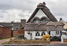 A thatched cottage in Wilstead, with the tower of All Saints Church visible in the background Wilstead Thatched Cottage.jpg