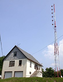 An August 2005 photo of WJIV's studio and tower. Derelict weather instruments atop the roof are a reminder of the daily "Weather Roundup" reports that aired on the Rural Radio Network. Wjiv.jpg