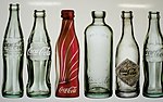Numerous historical Coke bottles