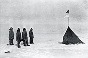 Roald Amundsen in njegova posadka opazujejo norveško zastavo na Južnem tečaju, 1911