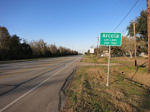 Arcola city limit sign is on FM 521 between Sears Road and Glendale Lakes Drive. The view is north.