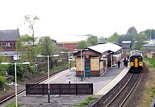 The entrance to a train station with a sign saying 