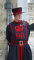Britisk yeoman warder (beefeater) i uniform med snitt frå tudortida. Drakta er dekorert med monogrammet til dronning Elisabeth II av Storbritannia (EIIR) Foto: Kjetil Bjørnsrud, 2002