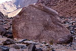 A large boulder at the base of Mount Sinai with carvings.