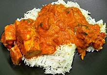 Chicken tikka masala, served atop rice. An Anglo-Indian meal, it is among the UK's most popular dishes. Chicken Tikka Masala KellySue.JPG