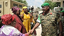 Shaking hands with a soldier in Mogadishu Congolese activist, Julienne Lusenge, shakes hands with an African Union soldier in Mogadishu, Somalia, on November 27. The Special Envoy on Women, Peace and Security of the Chairperson of the African (15272665883) (cropped).jpg