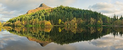 Reflexo do monte Pap of Glencoe e os bosques circundantes no Glencoe Lochan, um lago no lado norte de Glen Coe, nas Terras Altas escocesas. Encontra-se no extremo oeste da cordilheira Aonach Eagach, diretamente acima do ponto onde o rio Coe deságua no Loch Leven. Ele tem uma forma cônica distinta que lembra uma mama, particularmente quando visto do oeste. Faz parte da vista “clássica” da entrada de Glen Coe. (definição 9 456 × 3 817)