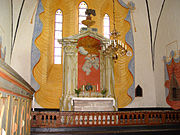 Koret med altaruppsatsen från 1792 omgivna av draperimålningar från 1700-talet.