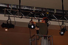 An electrician hangs stage lights Hanging stage lights.jpg