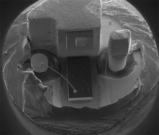 SEM (scanning electron microscope) image of a commercial laser diode with its case and window cut away. The anode connection on the right has been acc