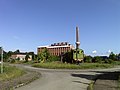 Totalidade do material da fábrica de briquetes Neukirchen, com os monumentos individuais: serviço úmido, serviço seco com sala de imprensa embaixo (nº 4, 5, hoje usado como local de eventos e para fins comerciais), centro elétrico (casa de máquinas) (nº 2, hoje restaurante), casa de carvão (nº. 1, hoje estúdio esportivo), apartamentos de empregados e administração (nº 3, hoje uso de escritório), bem como locomotiva de armazenamento a vapor tipo Meiningen, prensa de briquete e roda de caçamba de escavadeira (Obj . 09255952, mesmo endereço) e o galpão de empilhamento de peças agregadas chaminé, paiol e briquete