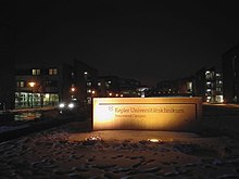 Der Neuromed Campus mit neuem schild im Februar bei Nacht.