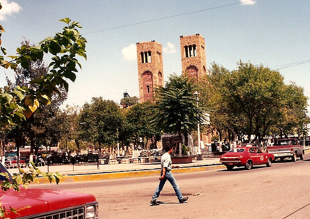 The Plaza Guillermo Baca in downtown Parral in 1992, showing the Searcher of Dreams Fountain and the Cathedral Shrine of Our Lady of Guadalupe, seat o