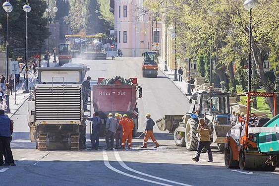 Workers repair the paved road surface . Baku, Azerbaijan