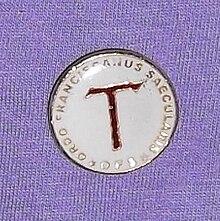 Secular Franciscans can be recognized by the Tau Cross they wear as a lapel pin (here) or pendant. Secular Franciscan Order, pin.jpg