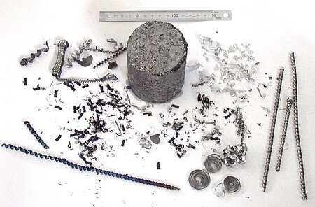 Various examples of metal swarf, including a block of compressed swarf. Broken up chips are preferred over stringy drill chips. SwarfSamples.jpg
