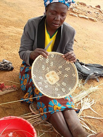 A Tonga woman pleating a basket