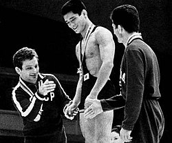 1964-ben az olimpiai eredeményhírdetésen (bal oldalt)