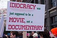 A placard raised during the 2017 Women's March describing Idiocracy as a "documentary"