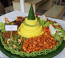 Tumpeng, yellow rice cone surrounded with various Indonesian dishes. One of the national dishes of Indonesia. Tumpeng.jpg