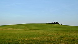 Kuželovitý vrch U oběšeného leží na katastrálním území obce Svratouch, na hlavním evropském rozvodí Labe – Dunaj (pohled od severozápadu)