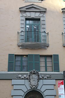 A portion of the stage house facade. The entrance arch with rusticated limestone voussoirs is at ground level. Above these are casement windows with shutters on the second story, as well as a French window with a small balcony on the third story. W 52 St Nov 2021 03.jpg