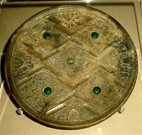 Zhou/Han bronze mirror with glass inlays, perhaps incorporated Greco-Roman artistic patterns (rosette flowers, geometric lines, and glass inlays). Victoria and Albert Museum. WhiteHanBronzeMirror.JPG