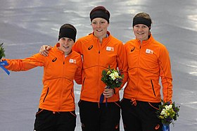 Lotte van Beek (höger) med Jorien ter Mors (vänster) och Ireen Wüst (mitten) på podiumet efter vinsten i lagtempo på vinter-OS 2014.[1]