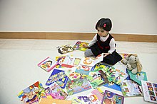 کودک در حال خواندن کتاب داستان